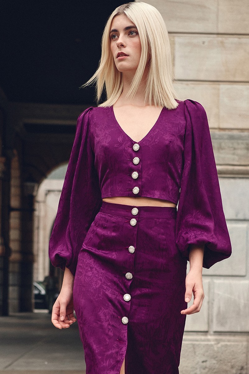 top morado con escote en pico boton joya y manga ablusonada