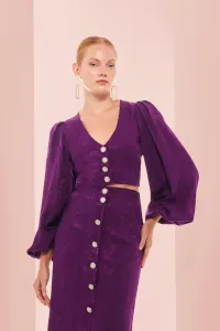 top morado con escote en pico boton joya y manga ablusonada