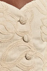 top lino beige con dibujo relieve para invitadas