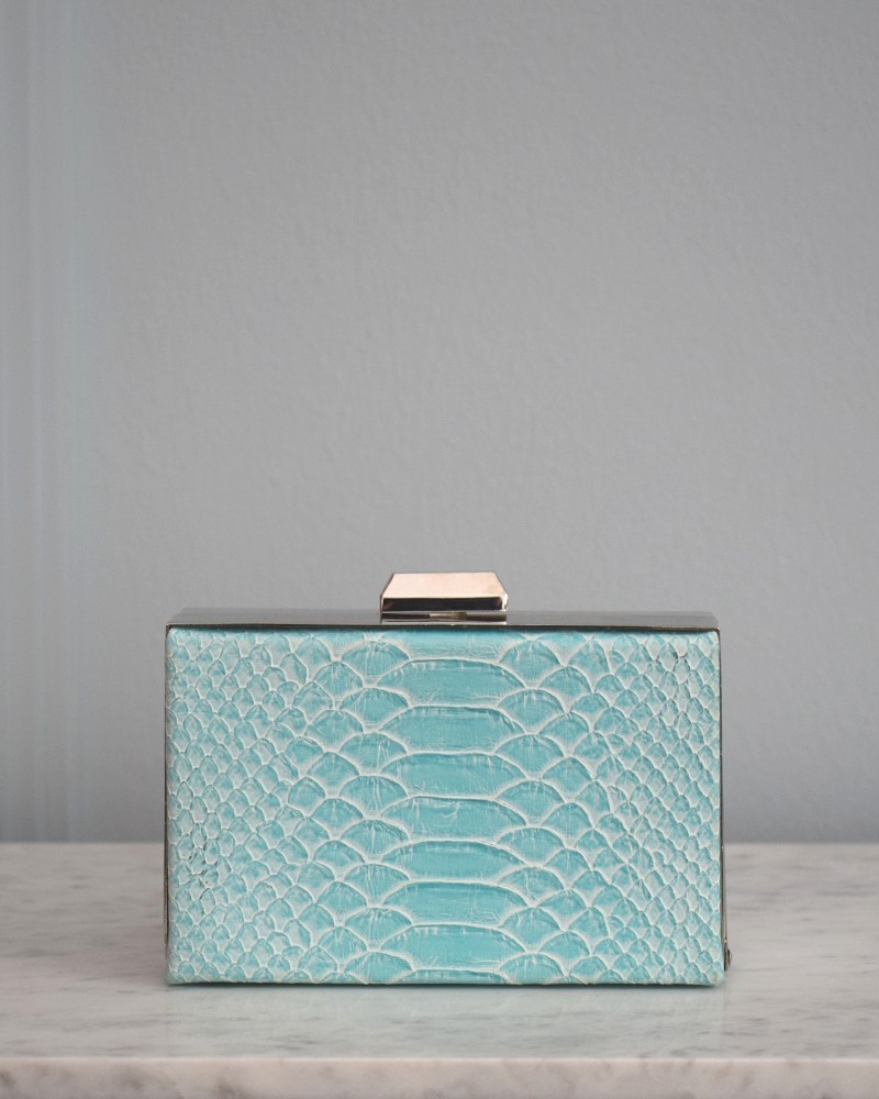 Bolso azul con joya de araña roja