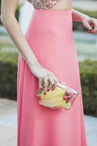 Bolso dorado con plumas amarillas y joya de insecto coral