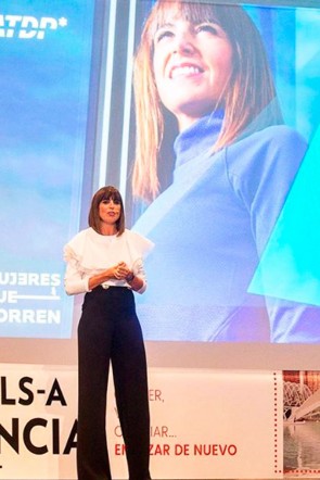 La periodista Cristina Mitre impartiendo una conferencia con blusa blanca volantes veracruz apparentia