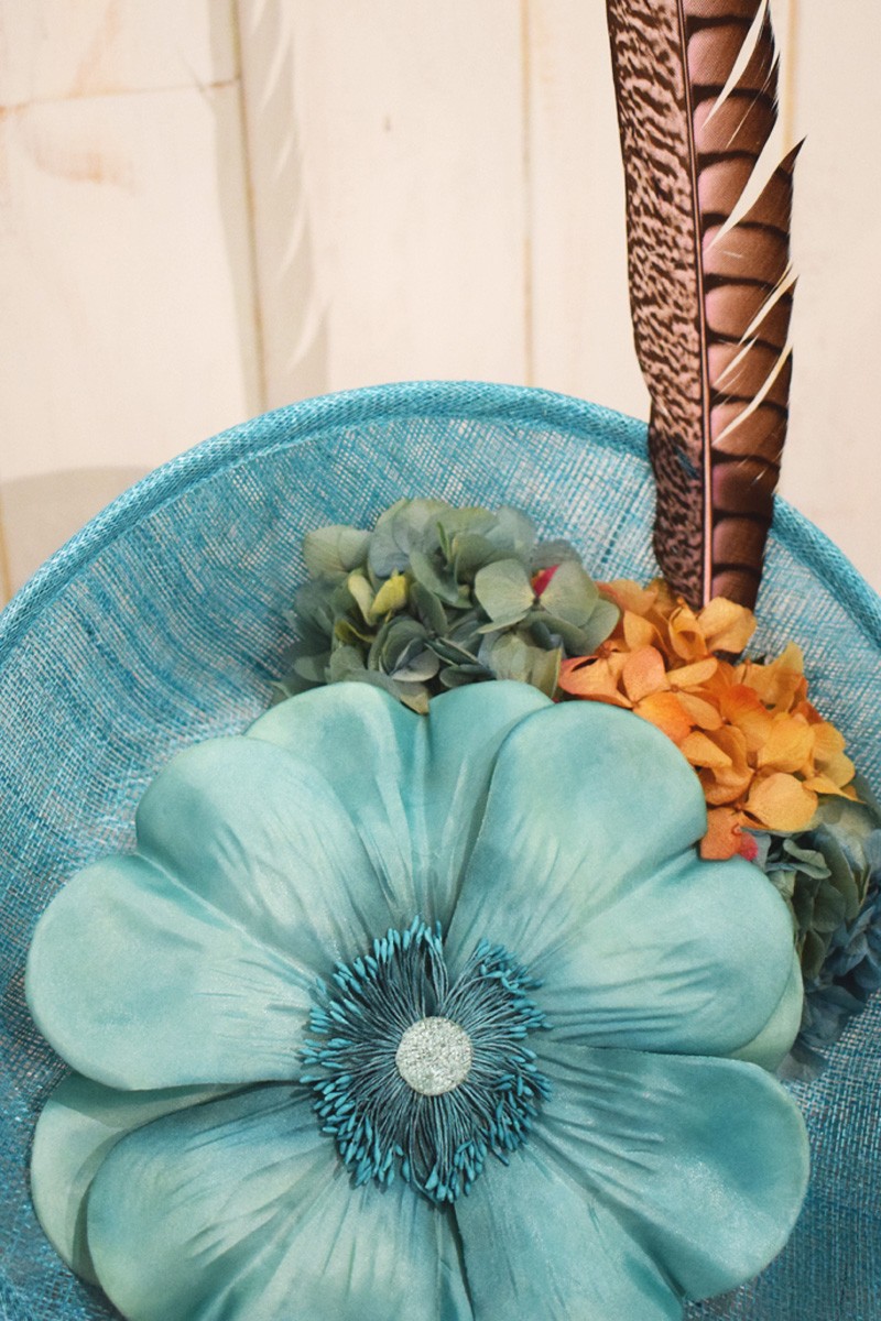 tocado de sinamay  azul claro con flor grande y pluma faisan para invitadas fiesta eventos de apparentia