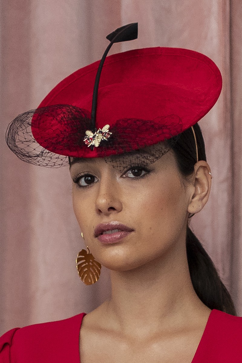 precioso tocado de ante de color rojo adornado con pluma redecilla lazo negro e insectos para invitadas eventos fiestas ocasiones especiales nochevieja bodas apparentia