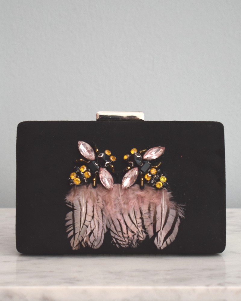 Bolso negro con joya en forma de insecto y plumas