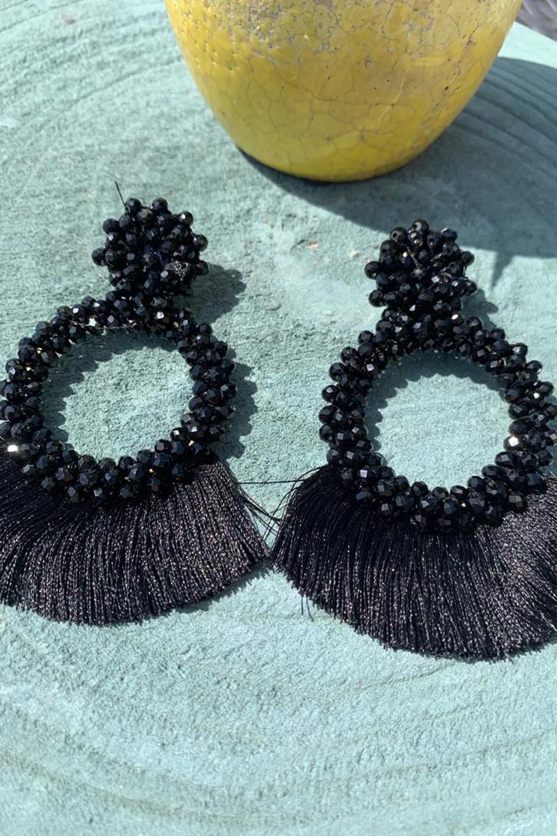 pendientes con engarces como de piedritas de coral negro en forma de estrella en la sujección y luego colgando en forma circulares de los que cuelgan flecos