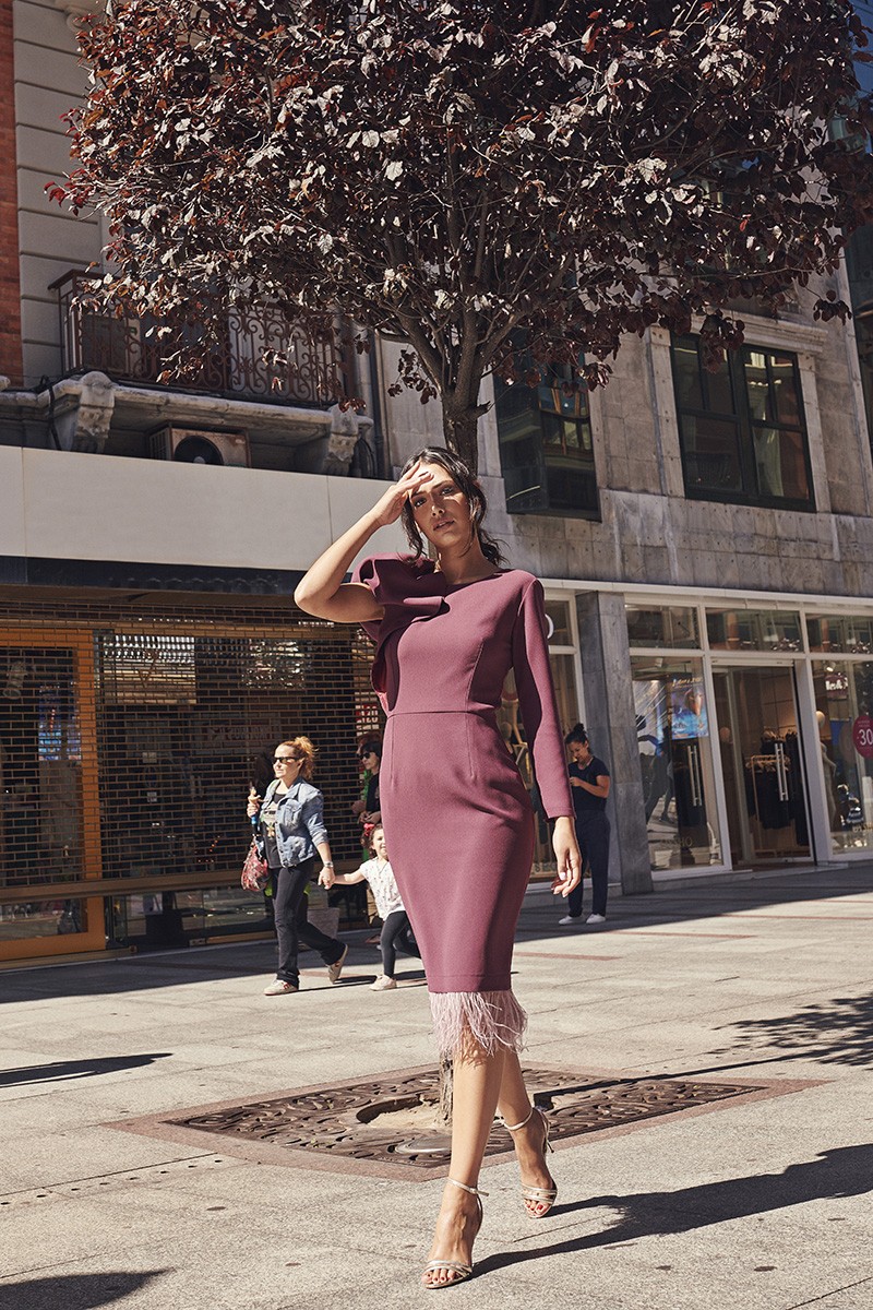 vestido de fiesta corto burdeos con plumas de avestruz en tono rosa y manga abullonada