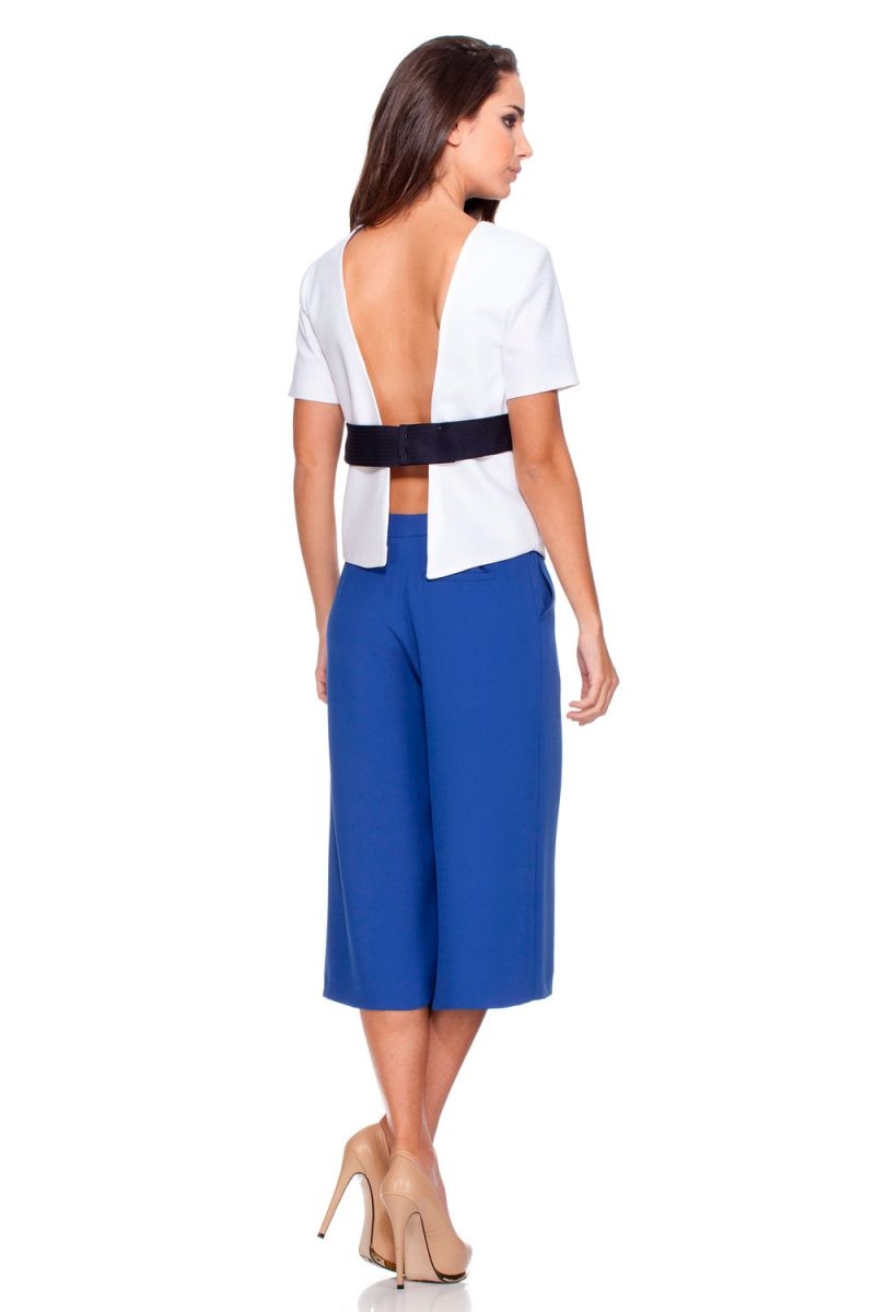 Top blanco con cinturón azul marino en contraste escote en la espalda totalmente abierta y unida por el cinturón de rocknrom blusa original con aire roquero para chicas jovenes