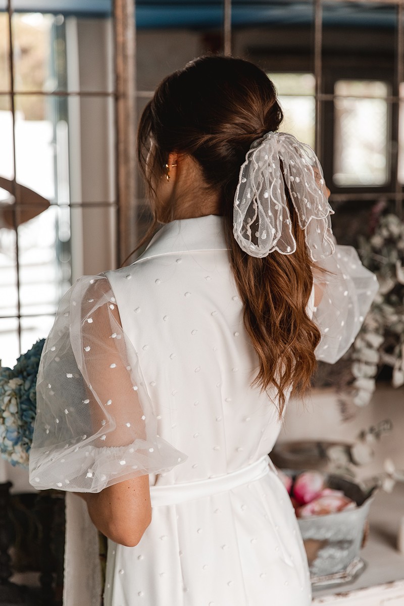 invitada perfecta con lazo de plumetti bordado en el pelo para novia civil
