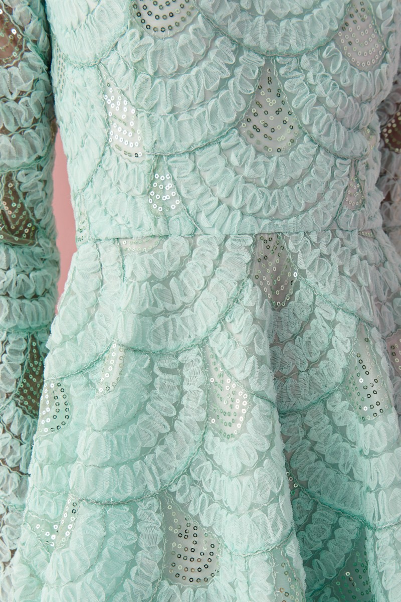  vestido largo de fiesta confeccionado en tejido de tul fantasía en color aguamarina con falda de gran volumen asimetrica, manga larga y escote en la espalda para invitada a boda de noche