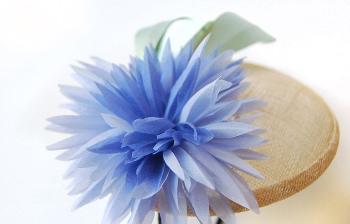 tocado para bodas eventos bautizos con flor morada y hojas verdes sobre diadema y base redonda de taneke en apparentia