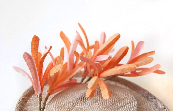 comprar online tocado con base redonda sobre diadema y plumas coral para look de invitada de boda bautizo evento de taneke en apparentia