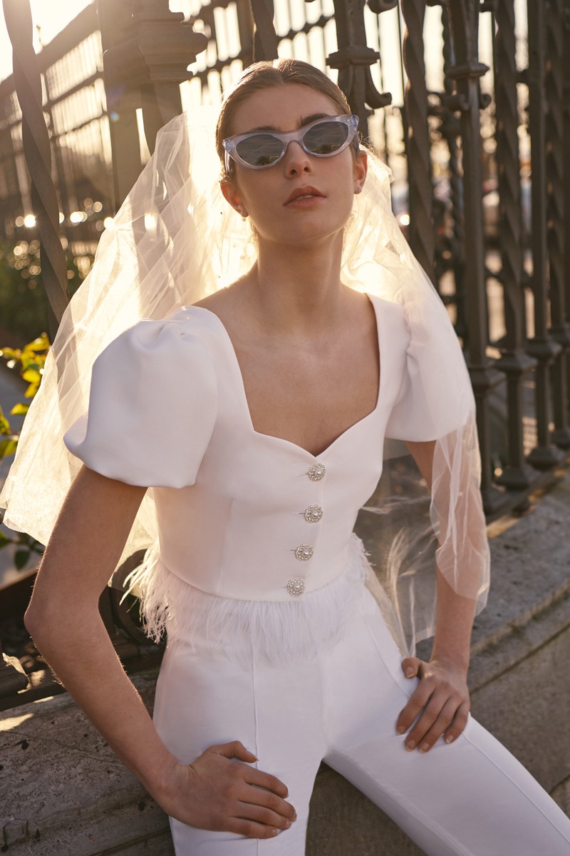 conjunto blanco de top corto con boton joya, escote corazon y plumas y pantalon palazzo para novia civil o boda informal mamá de bautizo o comunion