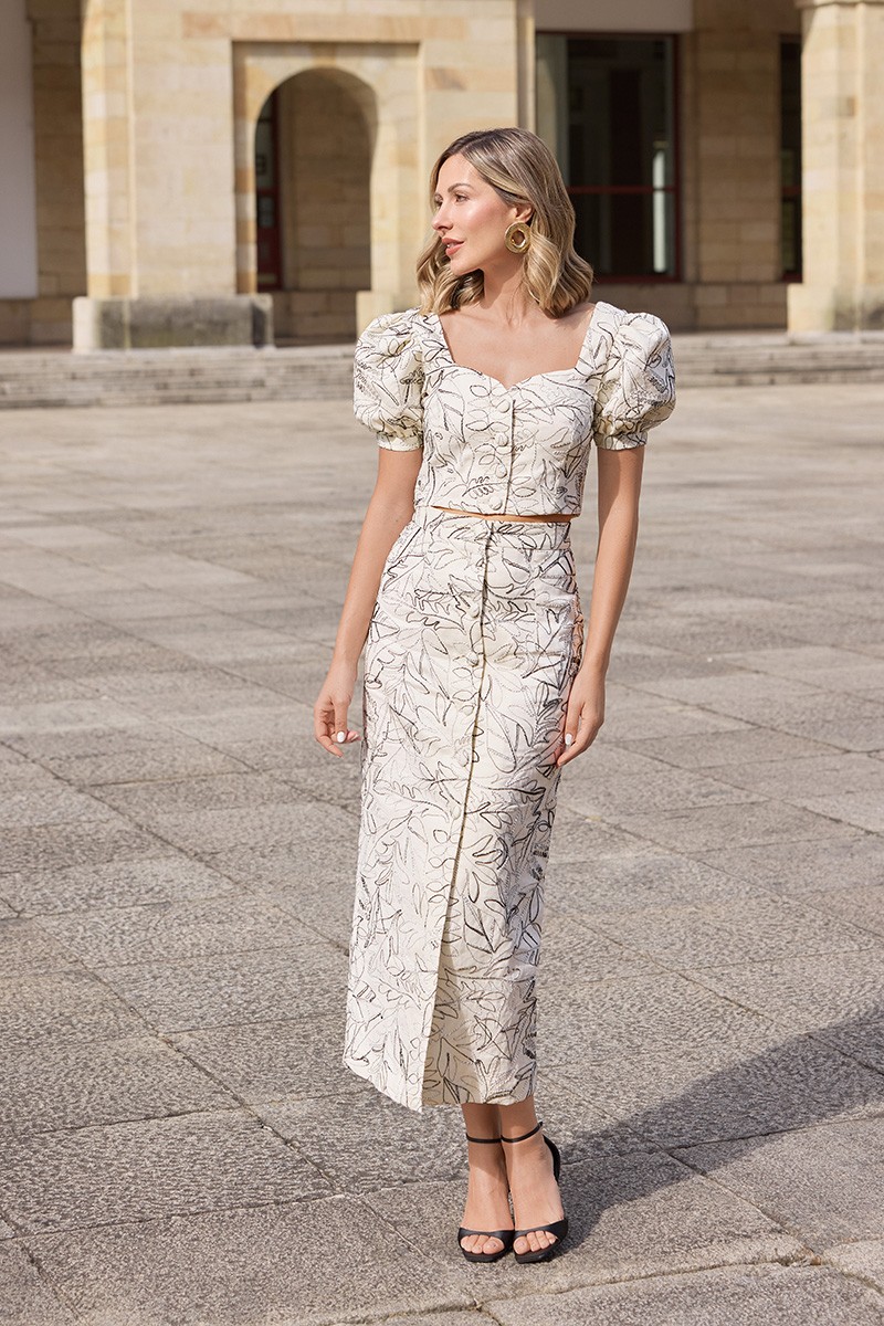 conjunto de  falda midi y top manga abullonada confeccionado en lino beige con bordados en relieve de gran calidad.